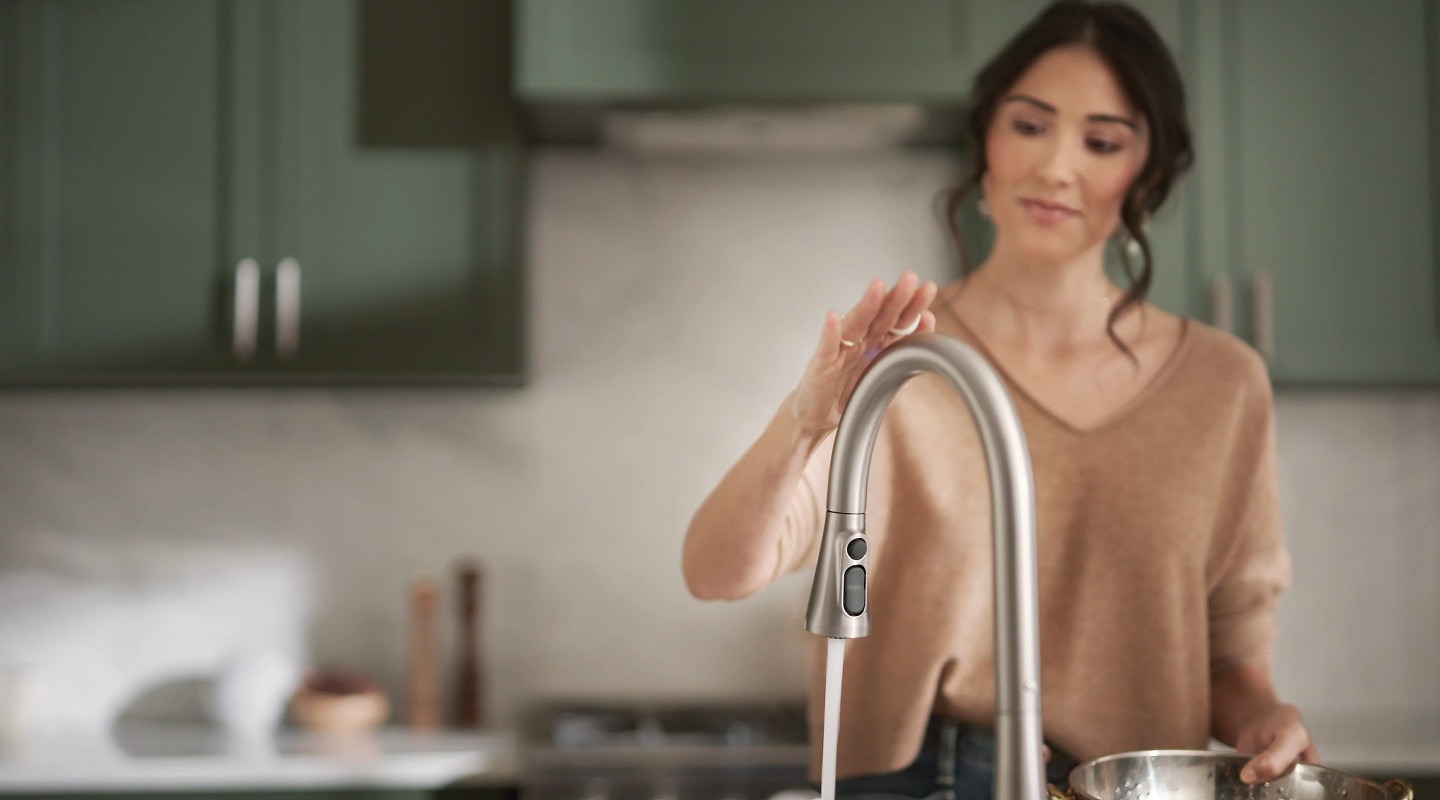 Women waving hand over faucet